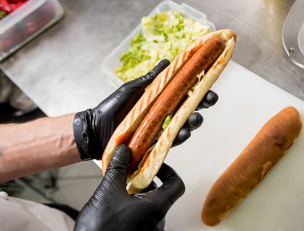 chef cuisinier hot-dog sur un grill. Restaurant.