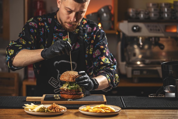 Chef cuisinier mettant un cure-dent sur un hamburger