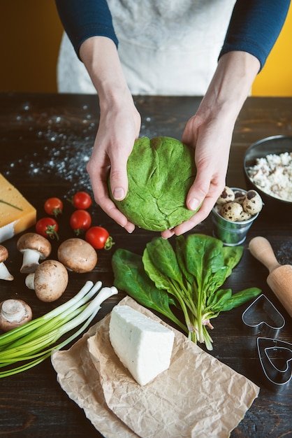 Le chef cuisinier prépare pas à pas des raviolis verts en forme de cœur pour un dîner de fête