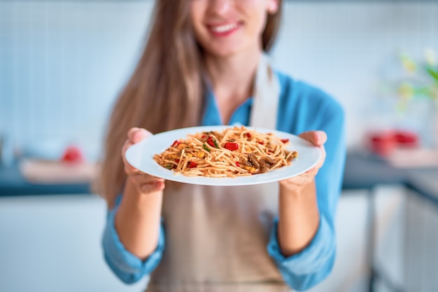 Chef cuisinier tenant une assiette de pâtes