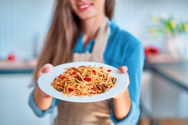 Chef cuisinier tenant une assiette de pâtes