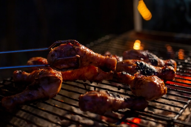 Chef de cuisson jerk barbecue poulet BBQ sur le grill main tournant la nourriture. viande grillée