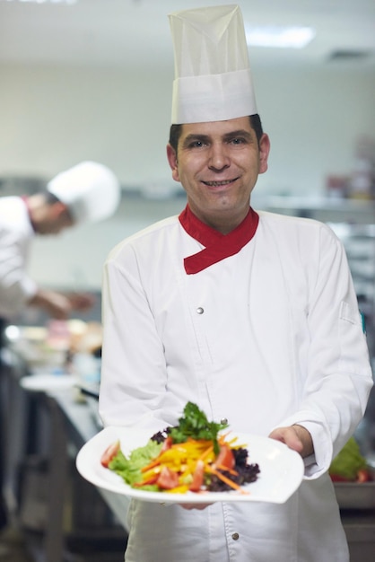 chef dans la cuisine de l'hôtel préparant et décorant des plats, de délicieux légumes et un dîner à base de viande