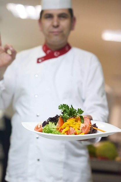 chef dans la cuisine de l'hôtel préparant et décorant des plats, de délicieux légumes et un dîner à base de viande