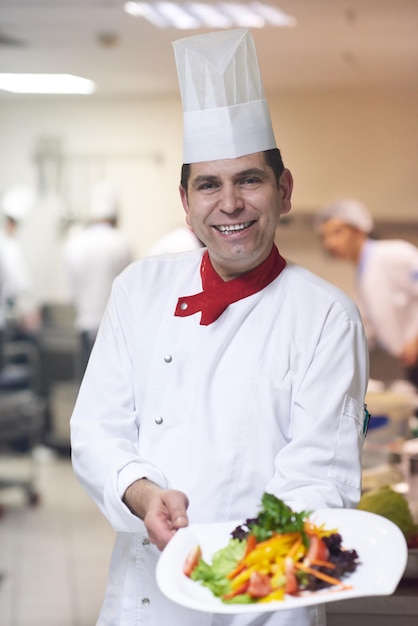 chef dans la cuisine de l'hôtel préparant et décorant des plats, de délicieux légumes et un dîner à base de viande