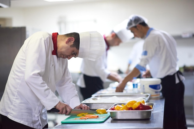 chef dans la cuisine de l'hôtel trancher les légumes avec un couteau et préparer la nourriture