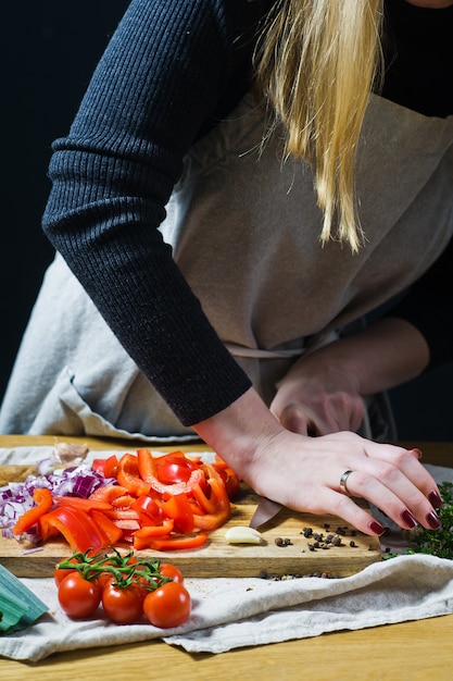 Chef écrase l&#39;ail sur une planche à découper en bois.