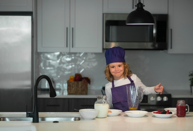 Chef enfant cuisine petit chef préparant un repas sain mignon enfant garçon en uniforme de chef dans la cuisine