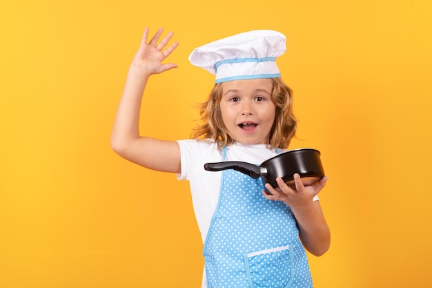 Chef d'enfant drôle cuisinier avec marmite de cuisine Enfant portant l'uniforme de cuisinière et toque de chef préparant la nourriture sur le portrait de studio de cuisine Cuisine culinaire et concept de nourriture pour enfants