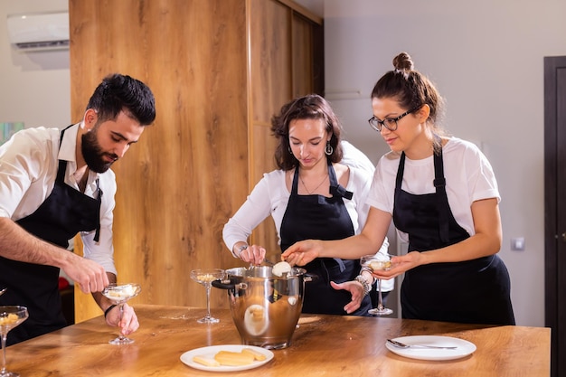 Chef enseignant aux stagiaires comment faire de la crème glacée en cuisinant de délicieux desserts à la crème glacée à base de chocolat et