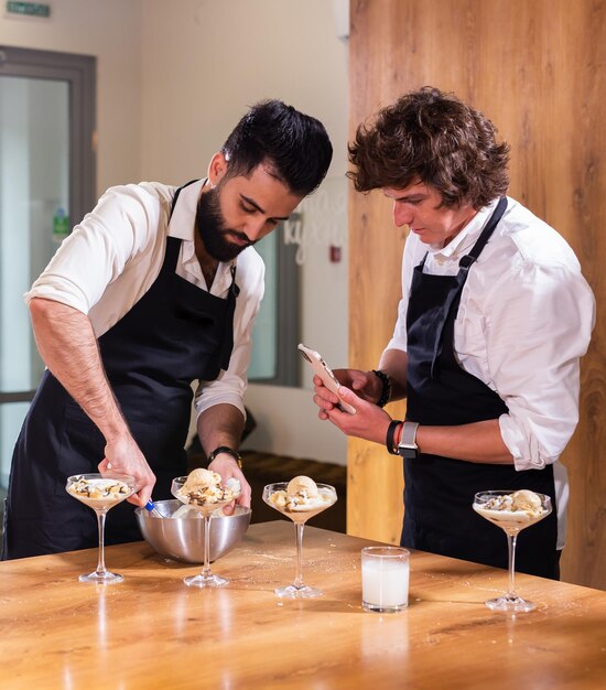 Chef enseignant aux stagiaires comment faire de la crème glacée Cuisson de délicieux desserts à la crème glacée à base de chocolat et de vanille dans un bol en verre