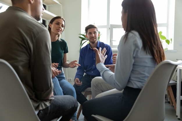 Un chef d'entraîneur masculin confiant parle d'un briefing d'écoute des employés de l'équipe au bureau expliquant la stratégie d'entreprise