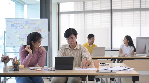 Chef d'entreprise masculin asiatique expliquant le nouveau projet et discutant du plan d'affaires de l'entreprise avec un collègue