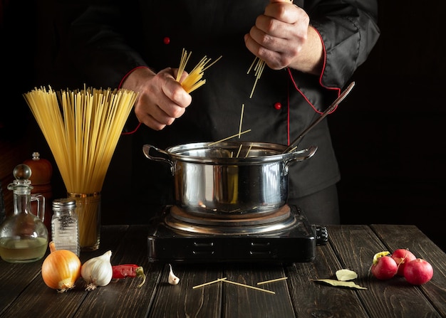 Chef expérimenté cuisinant des spaghettis dans une casserole Cuisiner une délicieuse soupe pour le déjeuner.