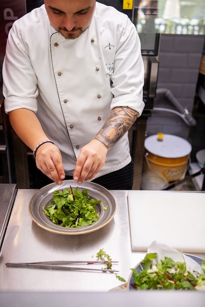 Chef faisant une délicieuse salade dans la cuisine du restaurant