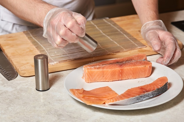 Chef faisant du poisson. Steak de saumon poivré