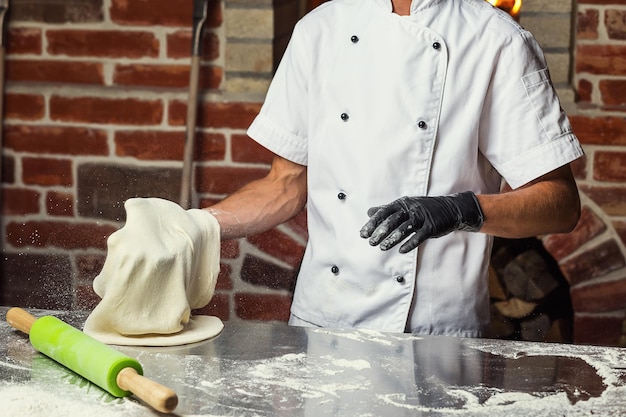 Chef faisant de la pâte à pizza Mains d'homme préparant du pain Concept de cuisson et de pâtisserie