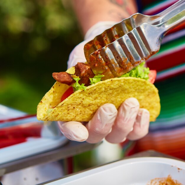 Chef faisant des tacos dans un café de la rue. mise au point sélective