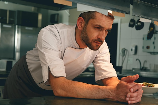 Photo chef fatigué au restaurant de cuisine en attente d'une nouvelle commande