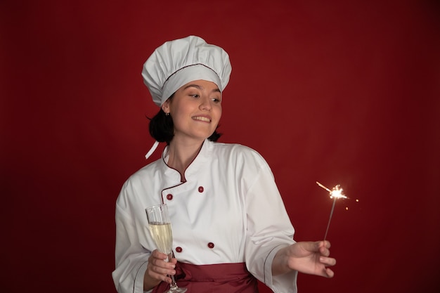 Chef féminin célébrant avec du champagne en verre et des cierges brûlants