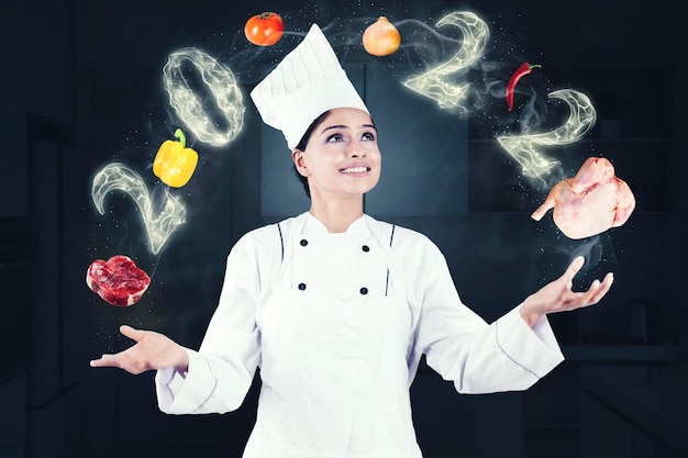 Chef féminin jonglant avec des aliments avec des numéros de 2022