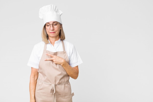 Chef femme avec main en forme de v sur la poitrine montrant la victoire ou la paix