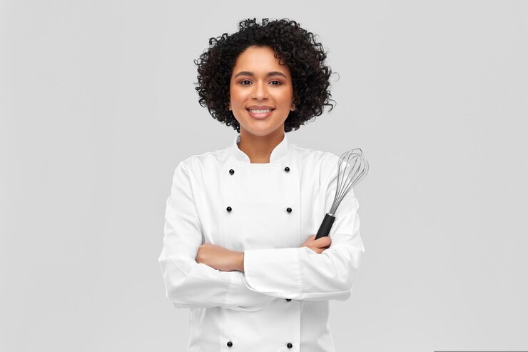 Photo chef femme souriante en veste avec fouet