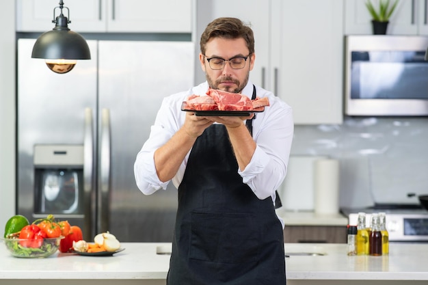 Chef avec filet de boeuf de viande crue sur la cuisine bel homme chef cuisinant le menu du restaurant de boeuf de viande crue