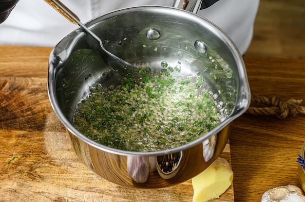 Un chef en gants noirs prépare des légumes sautés. Concept de cuisson des aliments biologiques sains