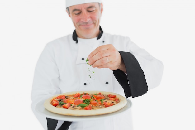 Chef garnir la pizza avec des feuilles de coriandre