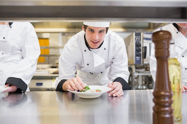 Chef garnir sa salade et souriant
