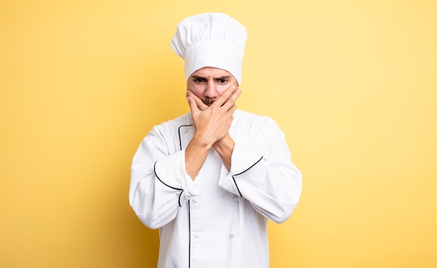 Chef homme couvrant la bouche avec les mains avec un choqué