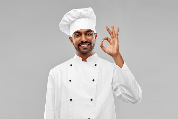 Un chef indien heureux dans un toque montrant un bon geste.