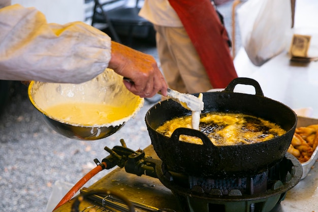 Un chef japonais cuisine du tempura dans un récipient avec de l'huile chaude à Tokyo