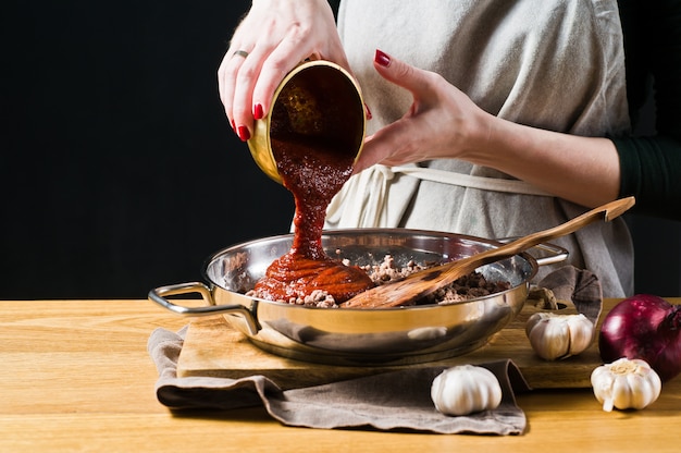 Chef Mains Verser La Pâte De Tomate Dans La Viande Hachée