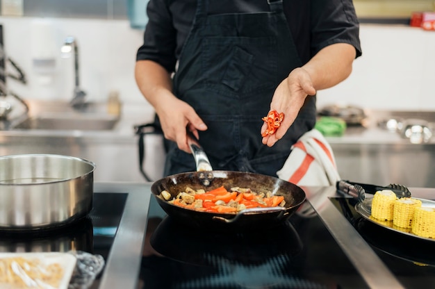 Chef masculin ajoutant du piment au plat