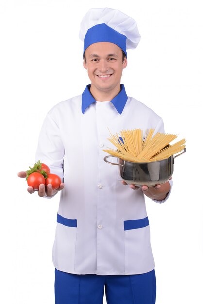 Chef masculin cuisiner des pâtes et sourire.