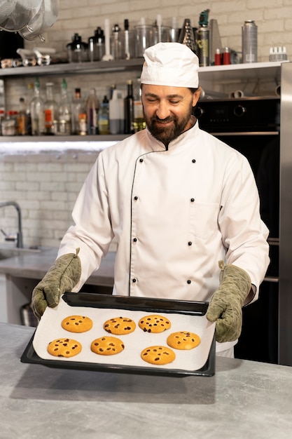 Photo chef masculin dans la cuisine faisant cuire des biscuits
