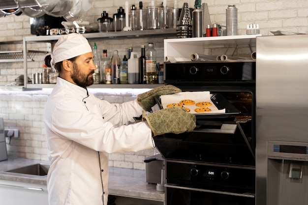 Photo chef masculin dans la cuisine faisant cuire des biscuits