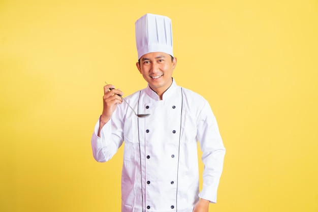 Chef Masculin Souriant Tenant Une Louche Sur Le Point De Goûter Des Aliments Sur Fond Isolé