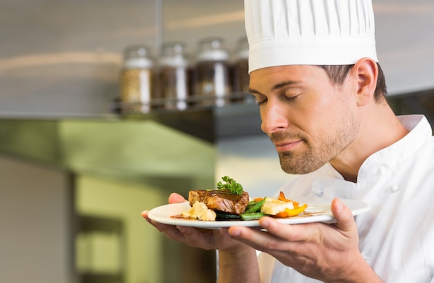 Chef masculin avec les yeux fermés sentant la nourriture