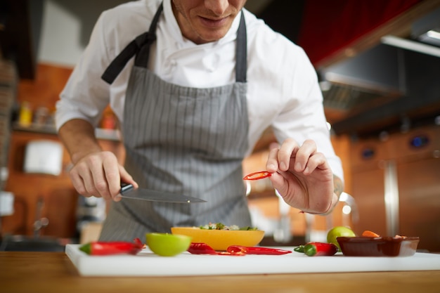 Chef méconnaissable coupant des légumes