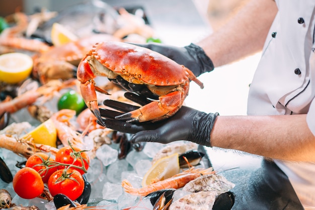 Le chef met les fruits de mer sur un plateau dans le restaurant.