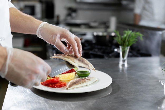 Le chef met le poisson dans une assiette