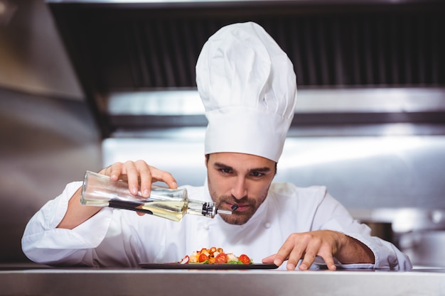 Chef mettant la touche finale sur la salade