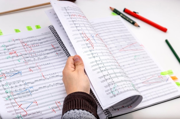 Photo chef d'orchestre étudiant les partitions de ses prochaines oeuvres