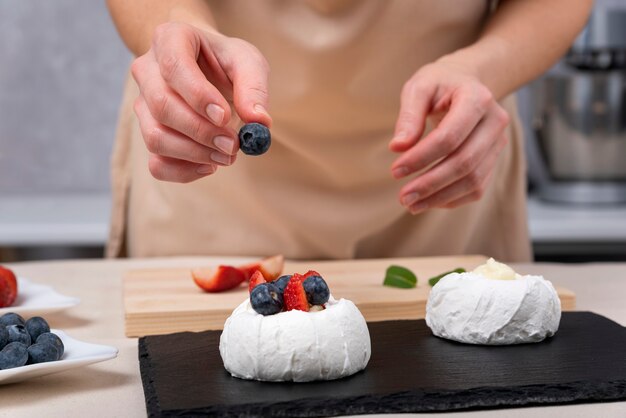 Le chef pâtissier décore les gâteaux avec des baies fraîches. Processus de fabrication de gâteaux.