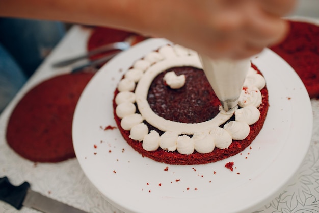 Le chef pâtissier fait un délicieux gâteau de velours rouge. Cuisiner et décorer un dessert.