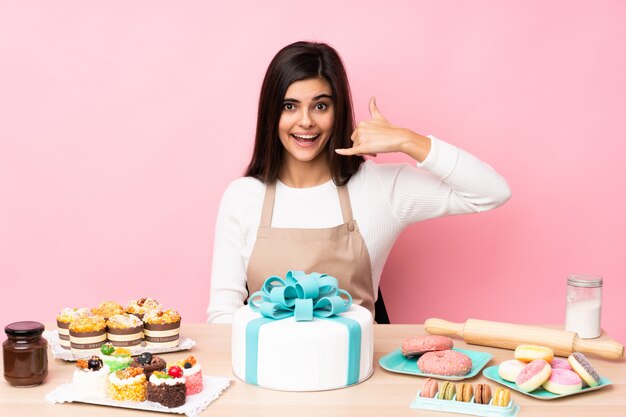 Chef pâtissier avec un gros gâteau dans une table