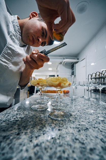 Photo chef pâtissier préparant un dessert sorbet mandarine